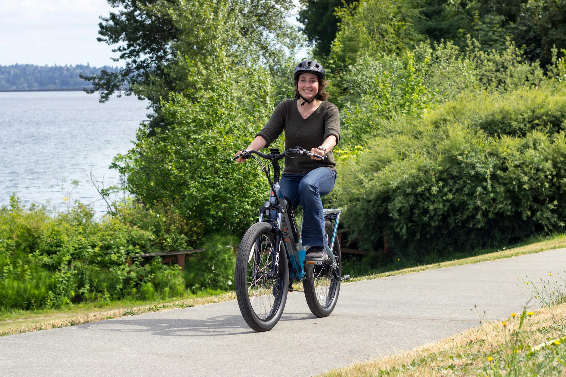 Kobieta jedzie na rowerze elektrycznym malowniczą ścieżką w Seattle