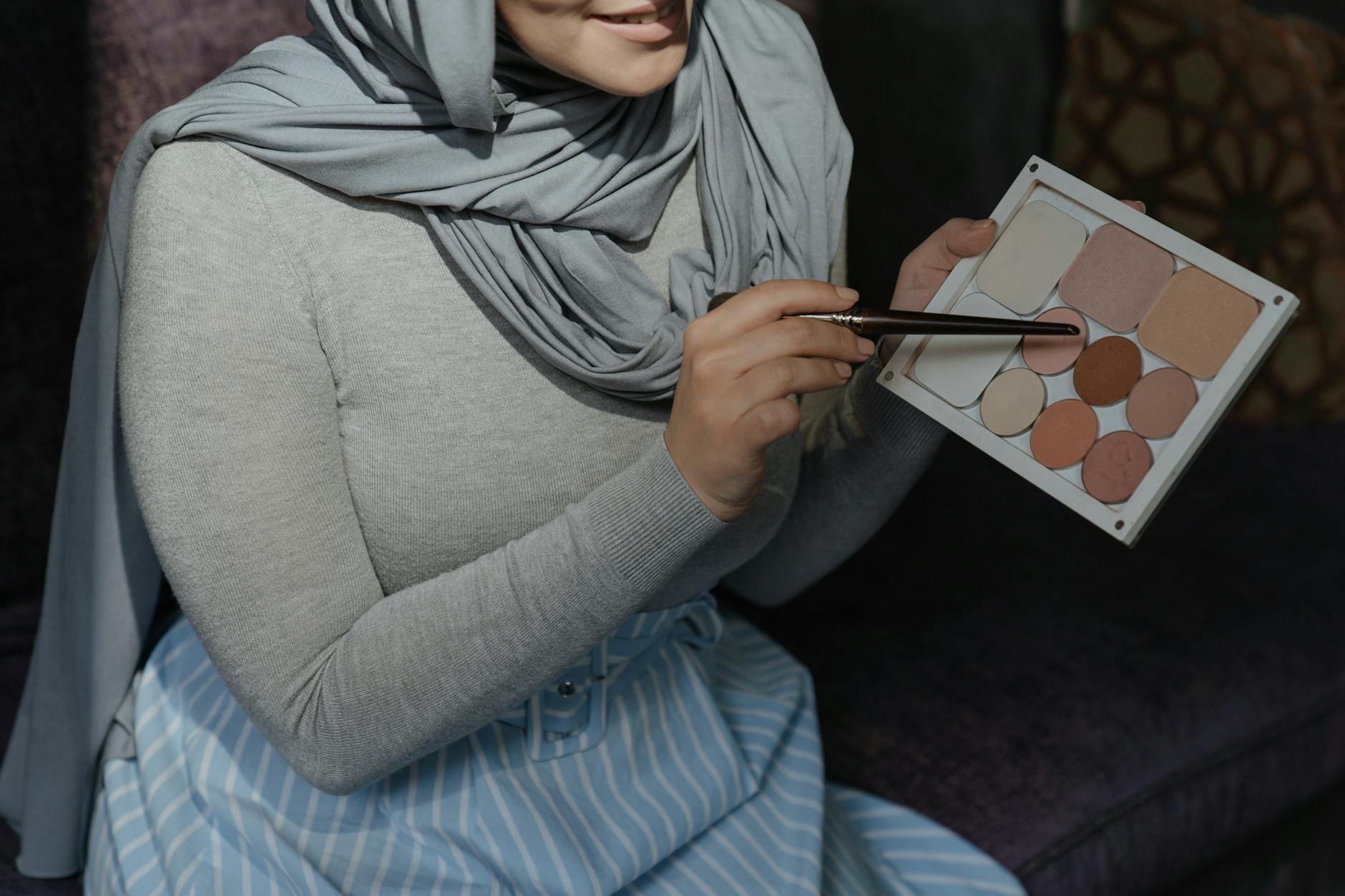 Muzułmanka w hijabie prezentuje paletę cieni do delikatnego makijażu
