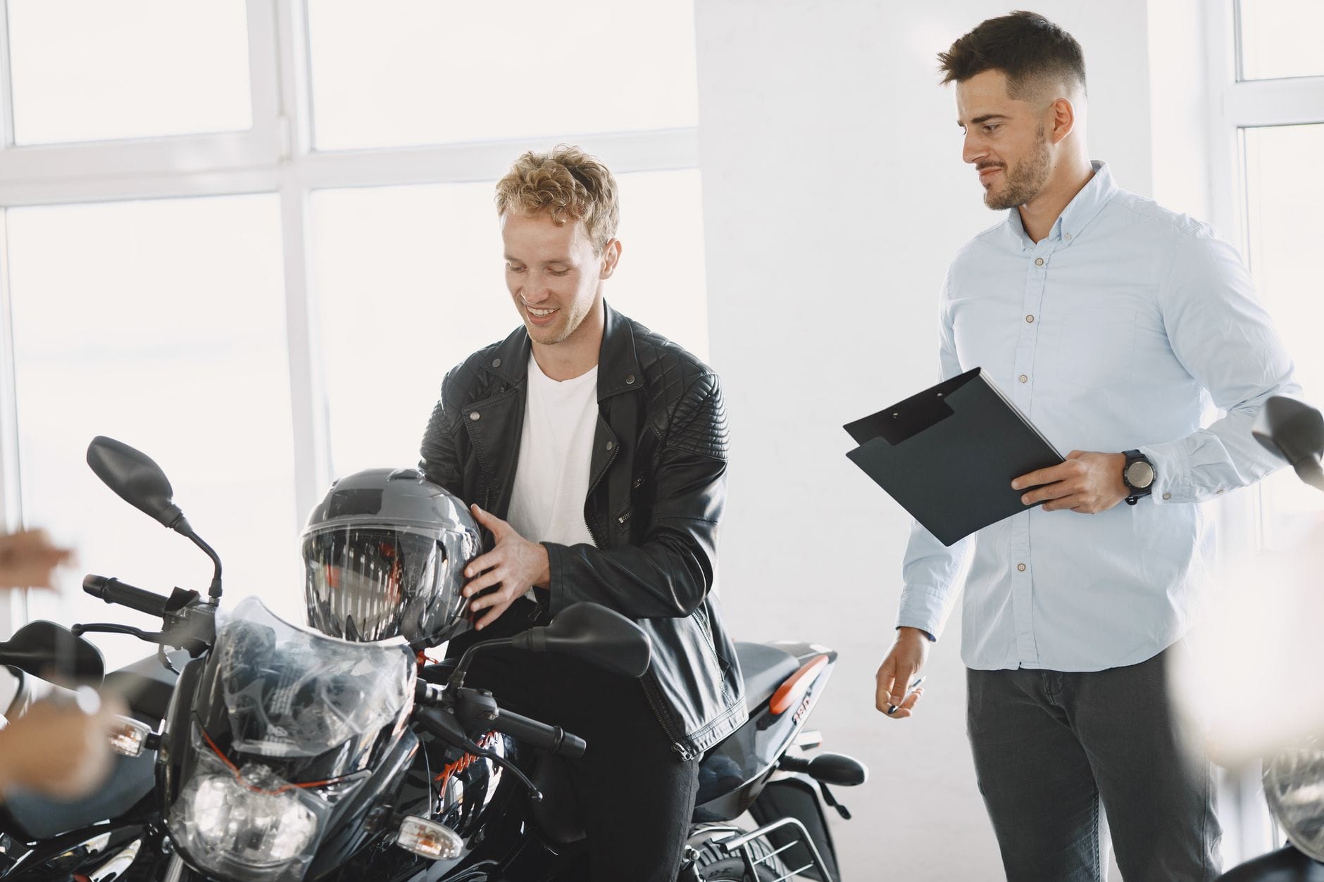 Dwóch mężczyzn rozmawia o zakupie motocykla w salonie dealerskim