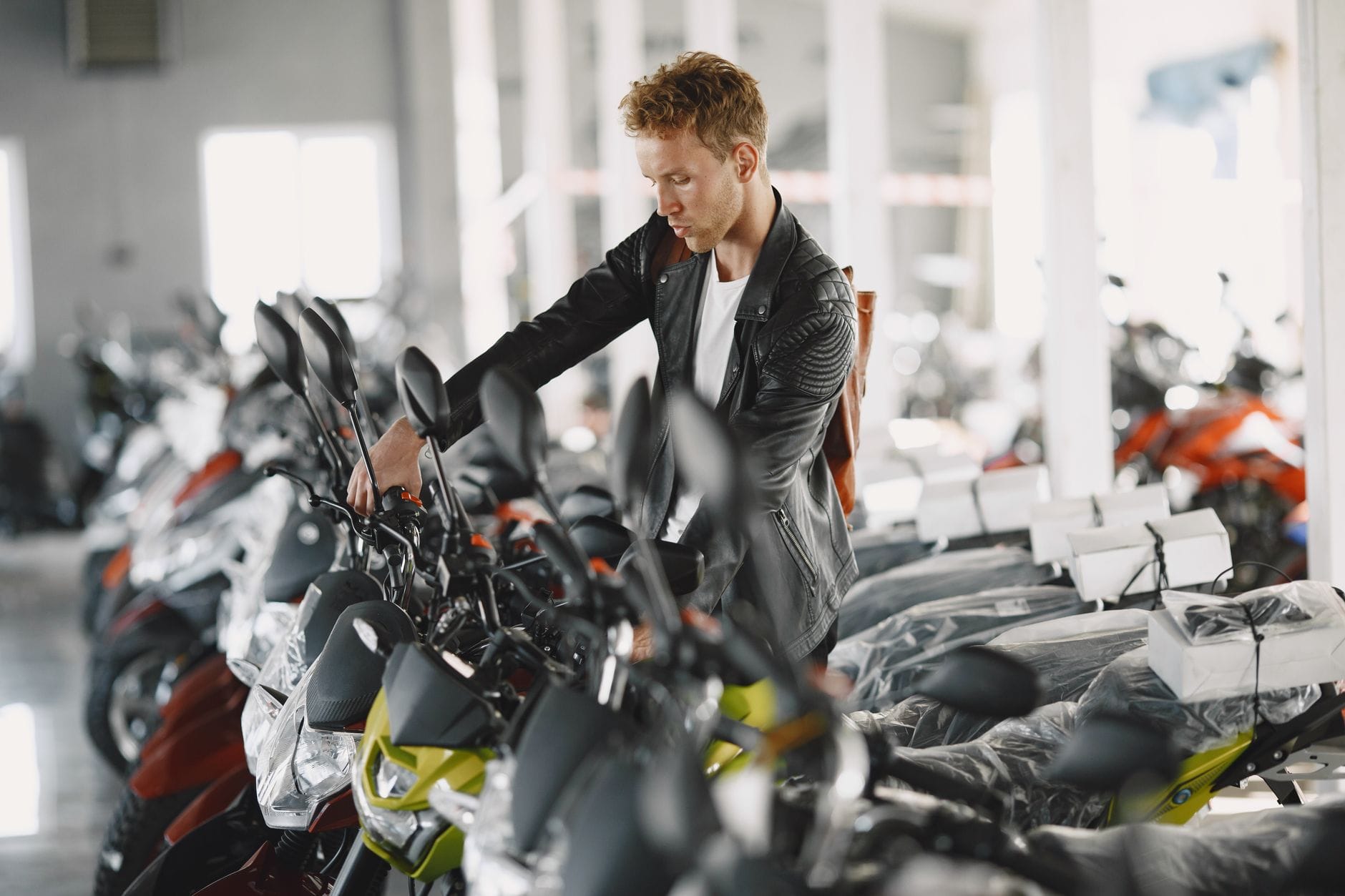 Mężczyzna ogląda motocykle w salonie dealerskim