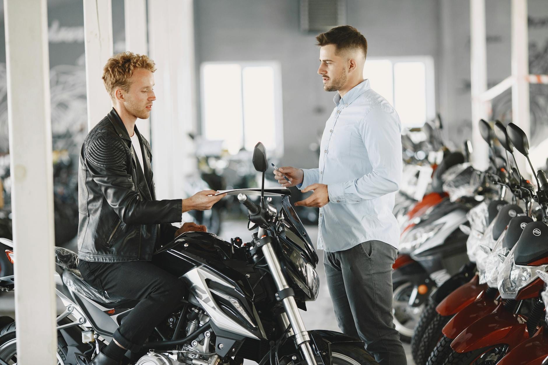 Sprzedawca rozmawia z klientem o zakupie motocykla w salonie