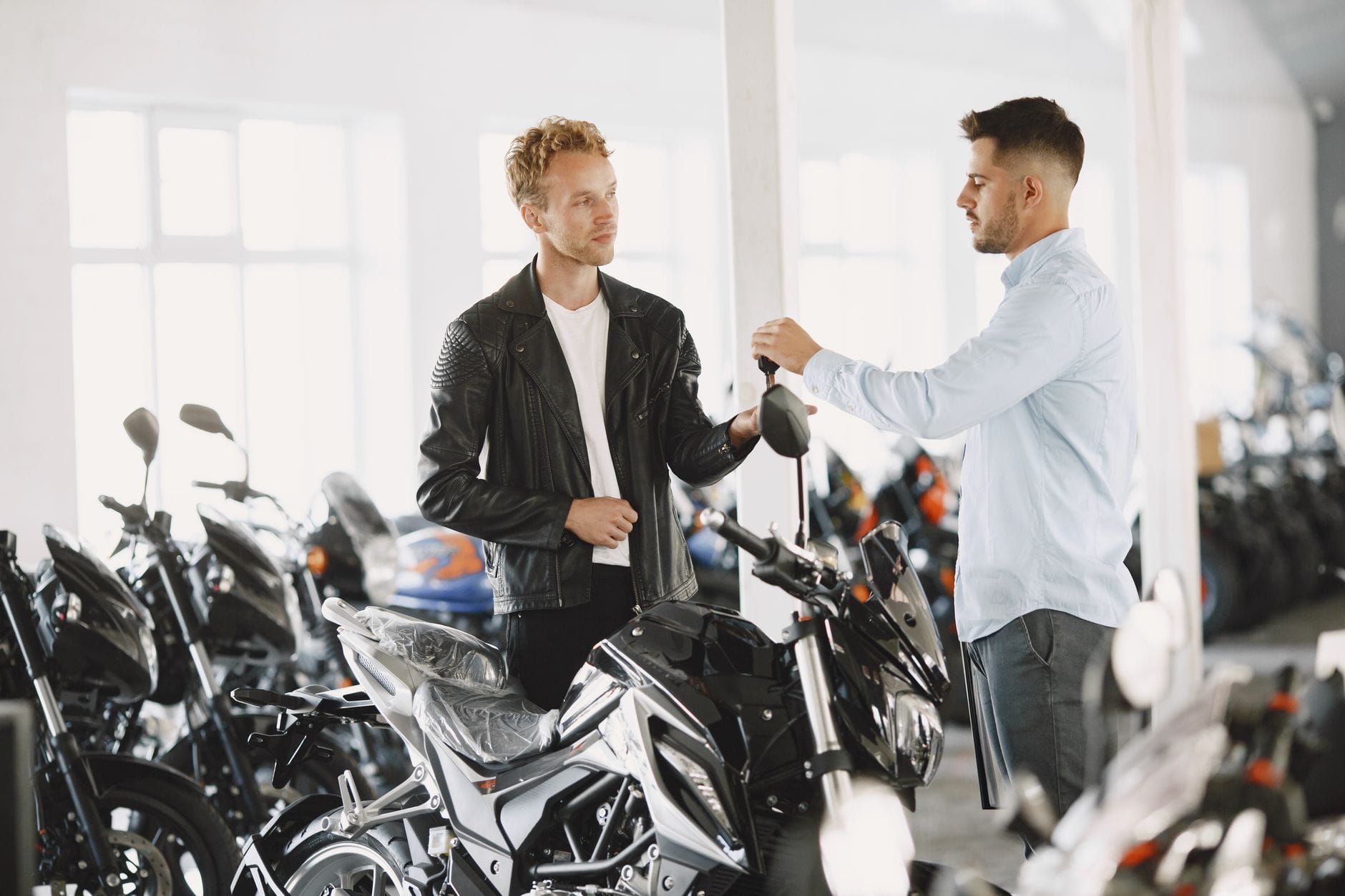 Sprzedawca rozmawia z klientem w salonie motocykli